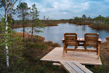 Naklejka premium Top view of two wooden chairs by the lake of the Kemeri National Park