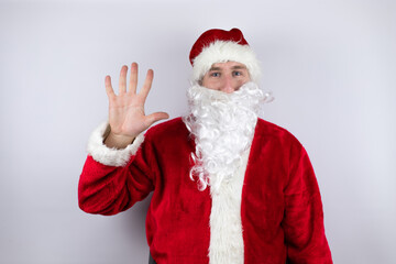 Fototapeta na wymiar Man dressed as Santa Claus standing over isolated white background showing and pointing up with fingers number five while smiling confident and happy