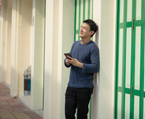 Man using smartphone outdoor. Portrait of young businessman using mobile phone while looking away on the street.