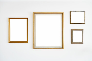 Vintage empty golden frames hanging on a white wall