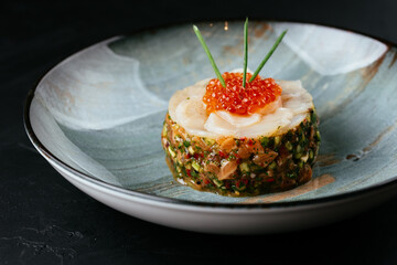 fresh salmon tartare with red caviar on a black background