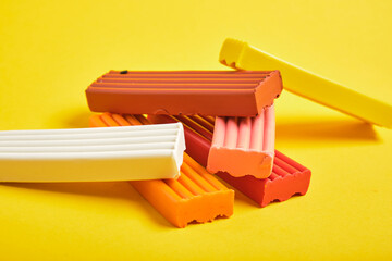 colored plasticine on yellow background copy space