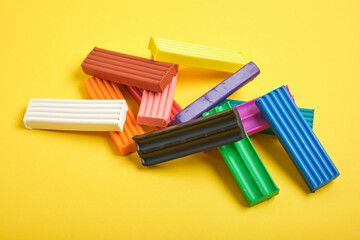 colored plasticine on yellow background copy space