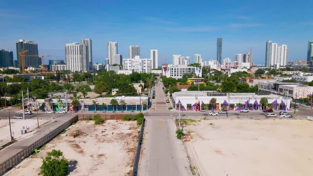 Aerial view over cars on the streets of Wynwood, Miami downtown background, sunny day, in Florida, USA - dolly, drone shot