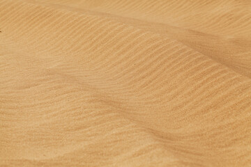 Yellow desert sand with diagonal wave patern.