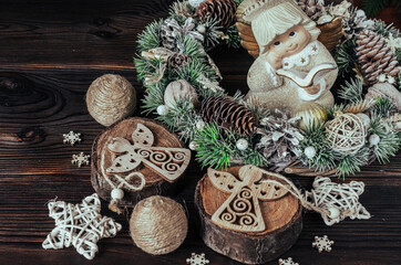 Christmas wreath, tree cuts, stars, snowflakes, figurine of an angel on a wooden background. Christmas composition.