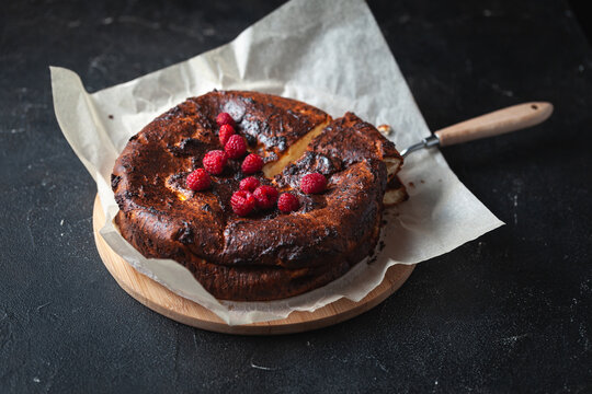 Burnt Hot Cheese Cake Out Of The Oven On The Parchment Or Baking Paper At The Black Background.