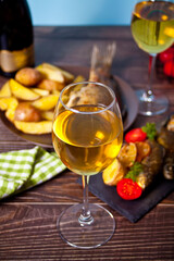 Glass of wine with grilled fish on plate with lemon and vegetables