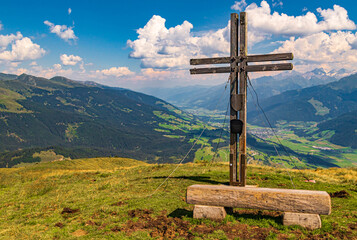 Beautiful alpine view with a summit cross at the famous Panoramabahn Kitzbueheler Alpen, Salzburg,...