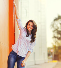 Summer portrait of attractive young brunette smiling woman in the city