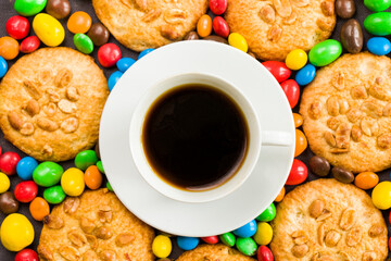 Cup of black espresso coffee and chocolate, candy and cookies on the gray background
