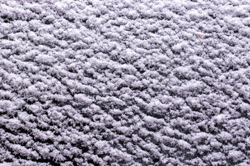 White snow covered black surface. Snow on the ground.