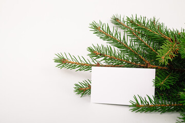 Fototapeta na wymiar Blank business card with christmas tree branches. New year celebration concept banner. Gift certificate. Side view. Minimalist mockup. Invitation to an event or party. Advertising information
