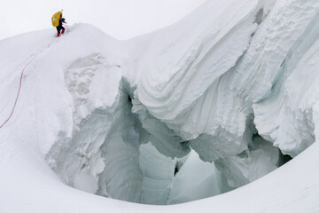 Mountain climber climb ice bridge (glacier). Descent from Marble Wall Peak, Central Tian Shan, Kazakhstan.