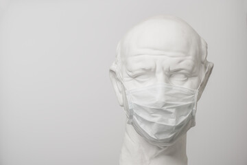 Coronavirus public opinion. Sculpture of a roman citizen wearing a medical mask.