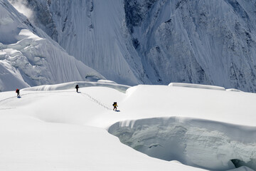 Mountain climbers go around glacier crack on the background of Tengri Tau Range. Central Tian Shan,...