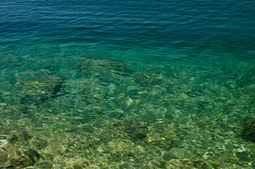 The rocky background of the sea throught turquois water