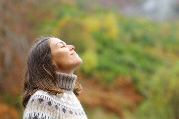 Middle aged woman breathing fresh air in a forest