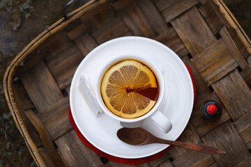 Flat lay with hot tea cup and a good slice of lemon and ginger to prevent colds in winter