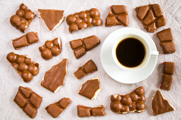Cup of black espresso coffee and chocolate bars on the white cloth background