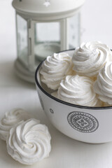 Fresh airy handmade vanilla marshmallows in a vase against a light background. Candlelight in the background.
