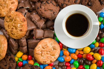 Cup of black espresso coffee and chocolate, candy and cookies