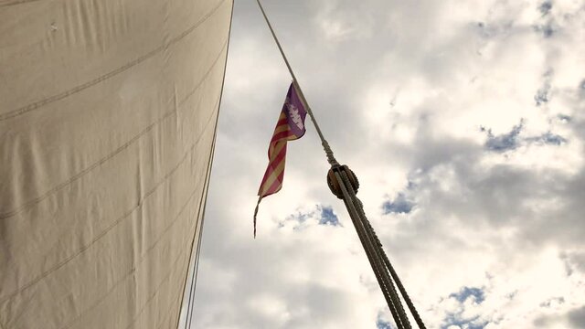 Ropes of a sail with a mallorcan flag on an old llaut boat