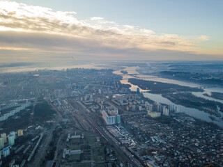 Aerial high flight over Kiev, haze over the city. Autumn morning, the Dnieper River is visible on the horizon.