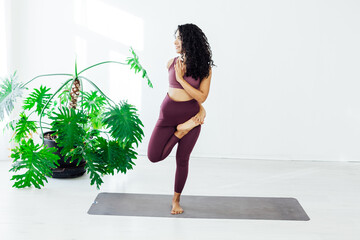 Beautiful female brunette yoga asana stretching the flexibility of the body fitness gym gym