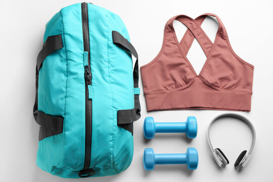 Flat lay composition with gym bag and sportswear on white background