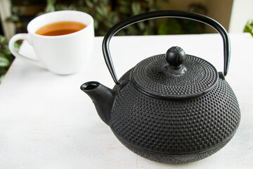 Obraz na płótnie Canvas Herbal tea, iron teapot and cup, chinese traditional tea serving