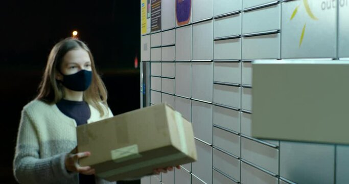 Woman Skans Bar Code and Put Parcel into Locker Cell to Send, Return or Deliver Box at Night. Modern Shipping and Internet Shopping Concept. Customer Uses Self-service Contactless Locker
