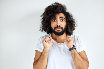 scared curly arabian young guy stand in fear by something, look at camera, isolated over white background.