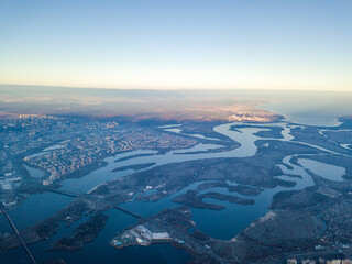Aerial high flight over Kiev, haze over the city. Autumn morning, the Dnieper River is visible on the horizon.