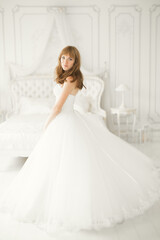 Fototapeta premium Luxury bride in white dress posing while preparing for the wedding ceremony