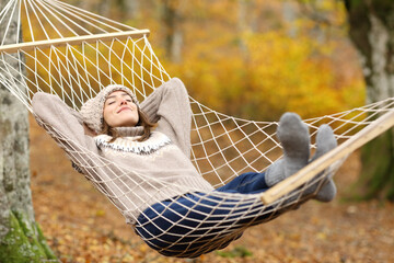 Relaxed woman resting on hammock in autumn holiday