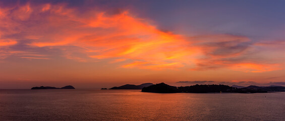 Fototapeta premium A panorama view of the vibrant stage of the sunset over the island of Bali, Asia