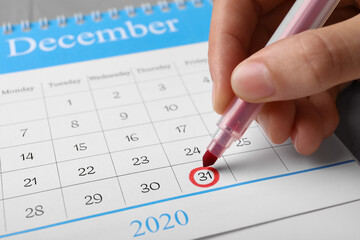 Woman marking date in calendar, closeup. New Year countdown