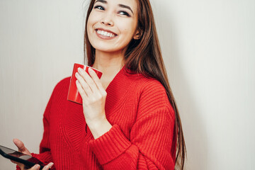 a asian girl in a red jacket and a red cup on a white background