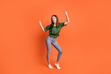 Fototapeta na wymiar Full length photo of lovely cute lady wear green off-shoulders blouse dancing isolated orange color background