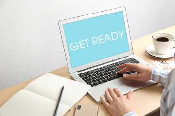 Woman using laptop with phrase Get Ready at table, closeup