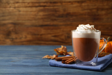 Delicious pumpkin latte on blue wooden table. Space for text