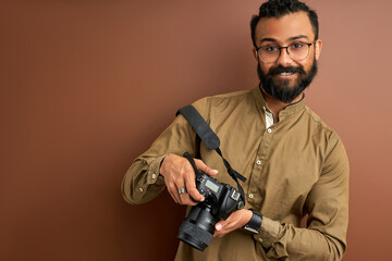 indian arabic photographer male with camera smiling, open-minded happy bearded guy take photo of people in studio