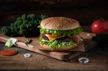 
Homemade hamburger and ingredients on wooden table
