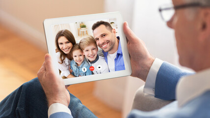 Senior Man Talking With Family Online Using Tablet At Home