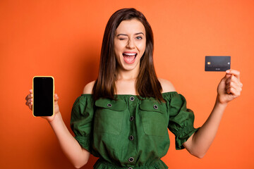 Photo of funny lady wear green off-shoulders blouse holding bank card modern device winking...