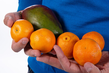 Exotic fruits in the hands of the guy. White background.