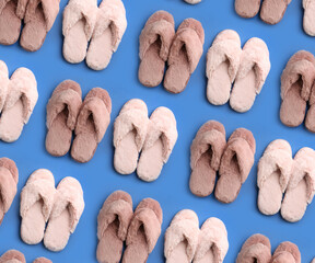 Soft slippers on blue background, top view. Pattern design