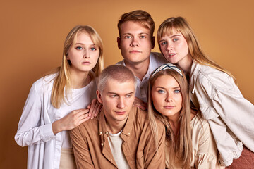 unusual group of extraordinary youth posing in trendy wear, caucasian models confidently look at camera isolated in studio