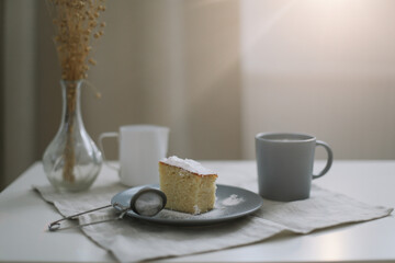 Piece of homemade cake with a cup of cappuccino on table with linen tablecloth. Morning breakfast. Top view, flat lay, copy space